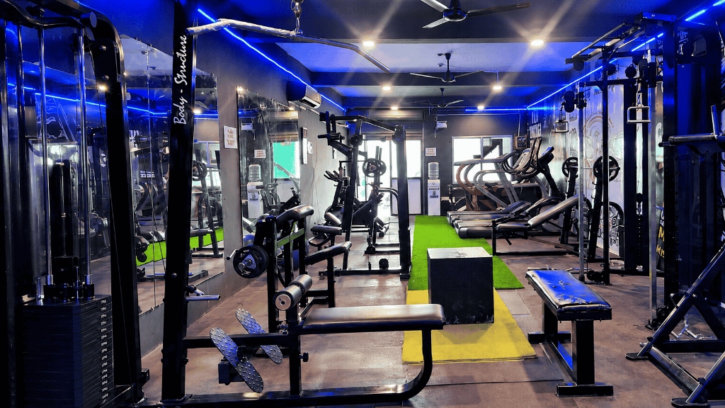 Main gym floor with cable crossover, benches and blue LED lighting